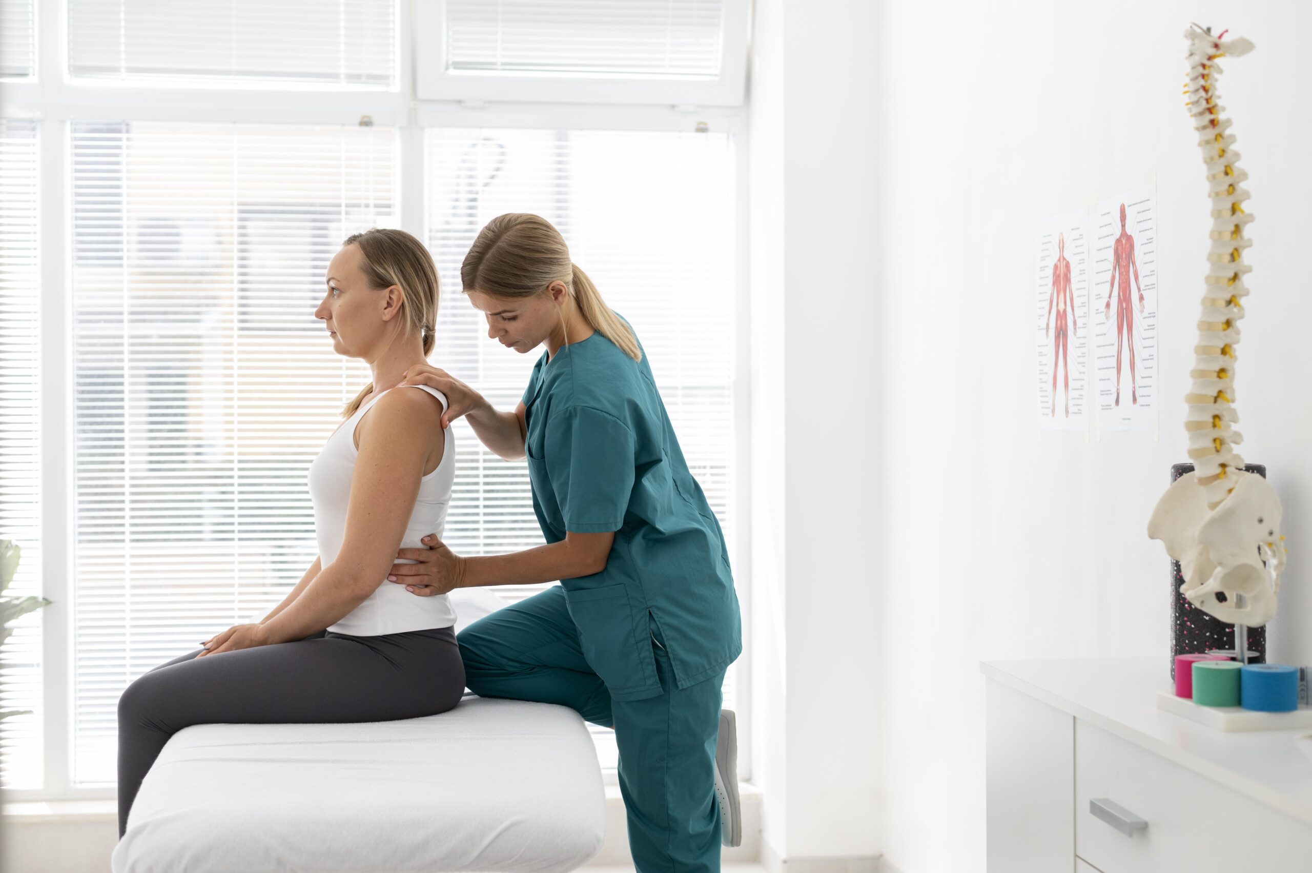 young physiotherapist helping patient with back problems